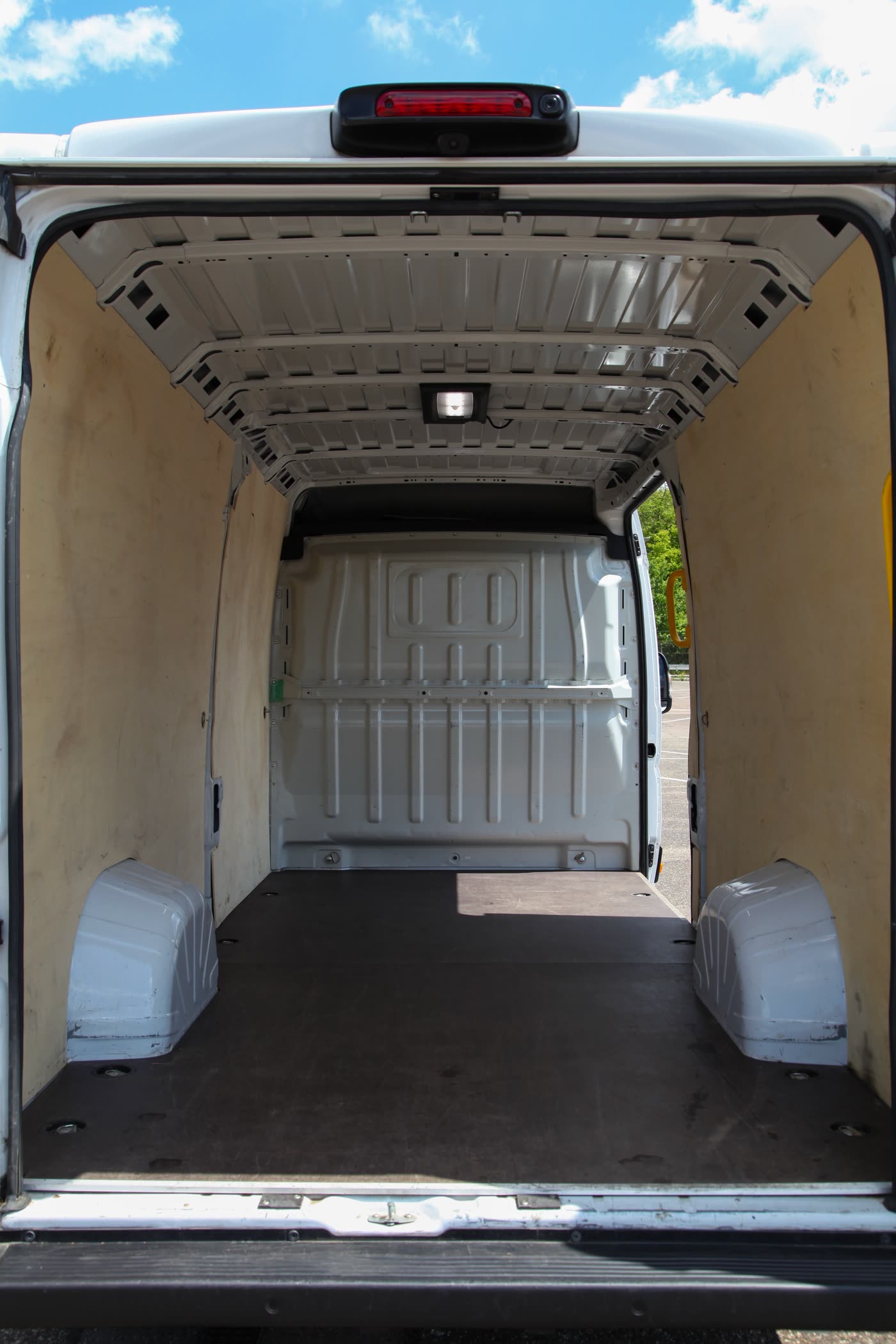 Laderaum des Peugeot Boxer – leerer Kastenwagen mit Holzverkleidung und Hochdach, Blick durch die Heck-Flügeltüren